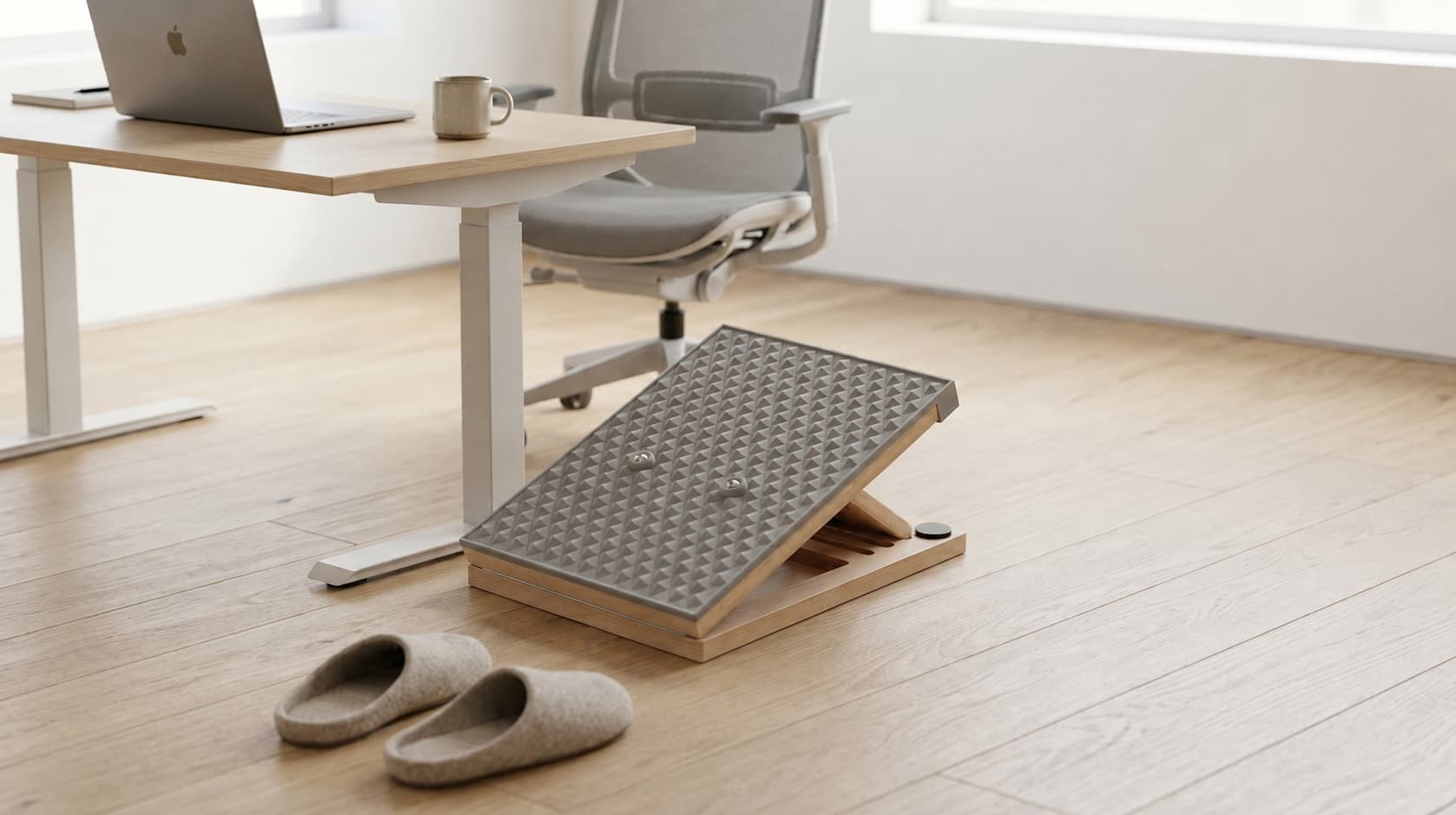 Wooden slant board with liquid silicone surface beside a home office desk for ankle mobility after sitting
