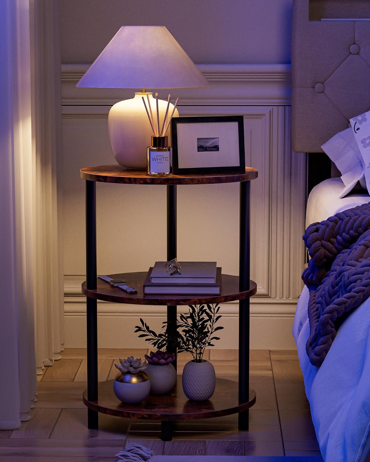 Cozy bedroom setup with Frylr rustic nightstand next to bed. 3-tier bedside table holding lamp, books, and decor for sleeping spaces.